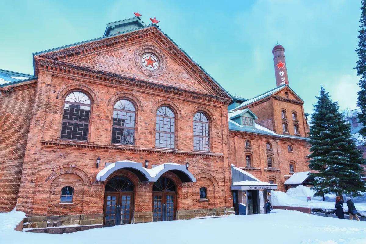 The red brick Sapporo Beer Museum surrounded by winter snow.