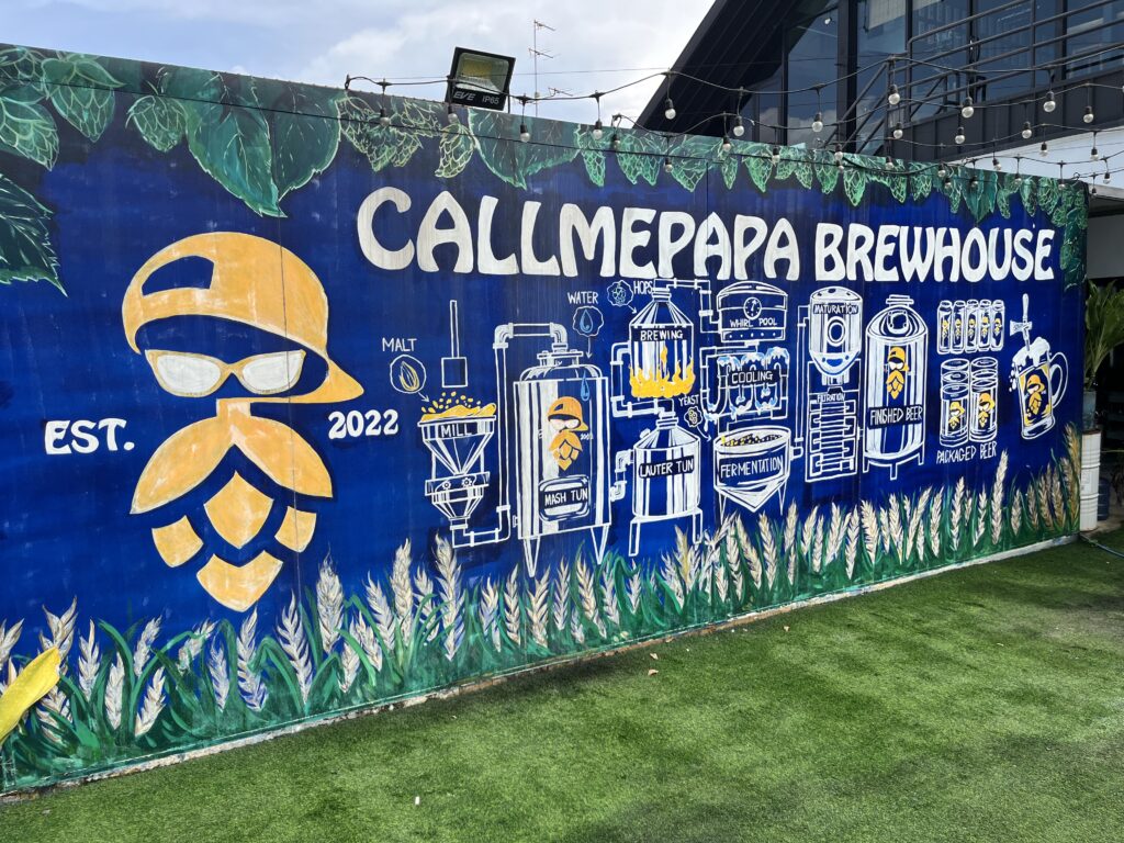 Mural outside Call Me Papa Brewhouse in Bangkok, Thailand, depicting the brewery's logo and brewing equipment.