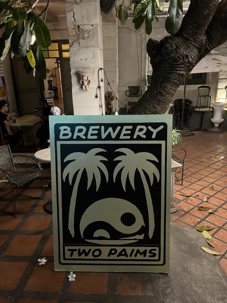 Signboard displaying Two Palms logo outside the brewery taproom in Bangkok, Thailand.