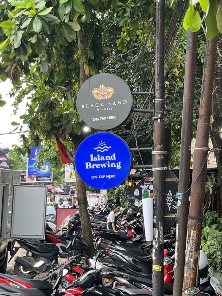 Signboards advertising the sale of Black Sand Brewery and Island Brewing in Lombok, Indonesia.